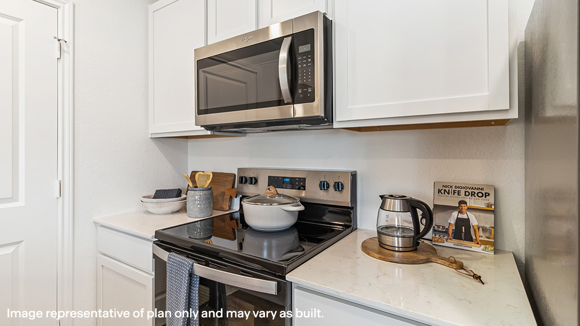 New appliances and central kitchen island with seating anchor the kitchen, next to dining, great room, backyard access