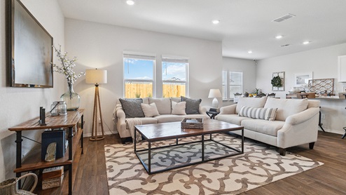 Hacienda Model Open-concept living area with hard surface flooring facing spacious kitchen.