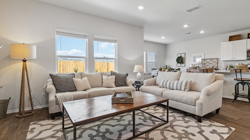 Hacienda Model Open-concept living area with hard surface flooring facing spacious kitchen.