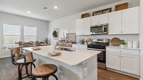Hacienda Model Open-concept kitchen with spacious corner pantry and plenty of cabinet space.