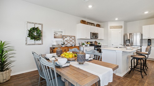 Hacienda Model Open-concept dining area overlooking spacious kitchen with hard surface flooring.