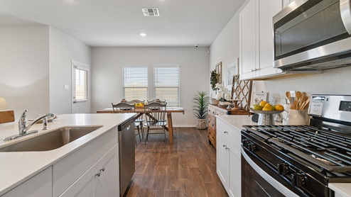 Hacienda Model Open-concept kitchen with spacious corner pantry and plenty of cabinet space.