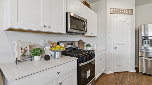 Hacienda Model Spacious, open-concept kitchen with island, shaker style cabinets and granite or quartz countertops.