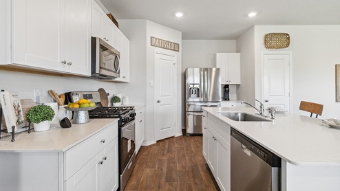 Hacienda Model Open-concept kitchen with spacious corner pantry and plenty of cabinet space.