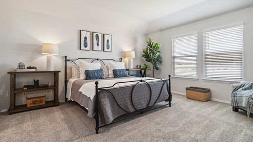 Hacienda Model Spacious primary bedroom with ensuite bathroom and walk-in closet.