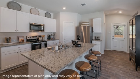 Spacious, open-concept kitchen with island, shaker style cabinets and granite countertops.