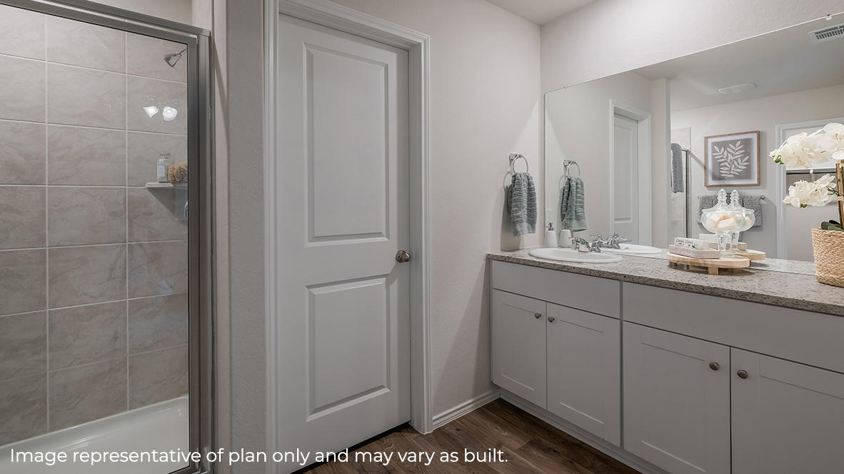 Spacious primary bathroom with walk-in shower, plenty of counterspace, single vanity sink and hard surface flooring.