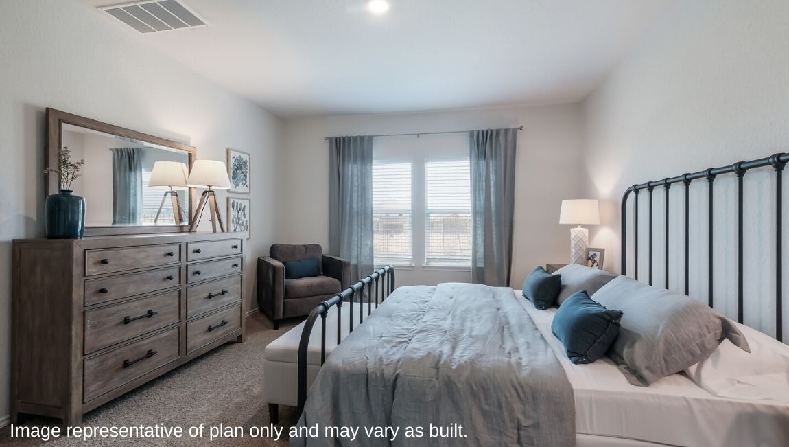 Spacious primary bedroom with windows and walk-in closet.