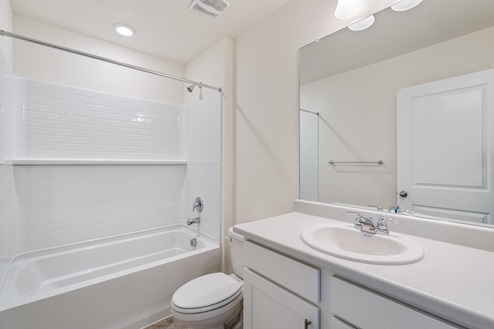 bathroom with white cabinets and a tub
