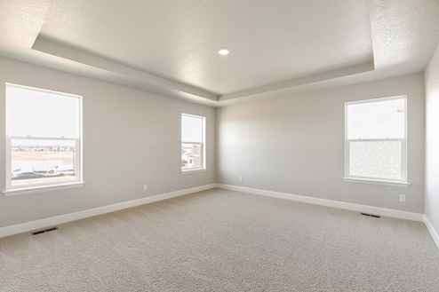 bedroom with three windows and crown molding ceiling