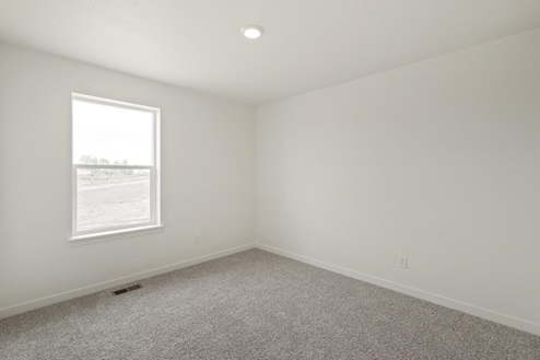white wall bedroom with a window and carpet floor