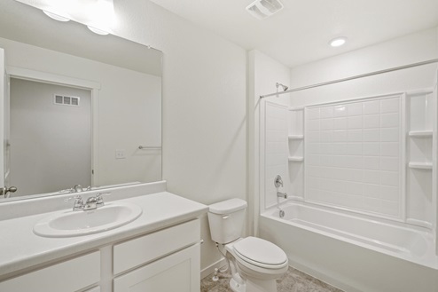bathroom with a tub and white cabinets