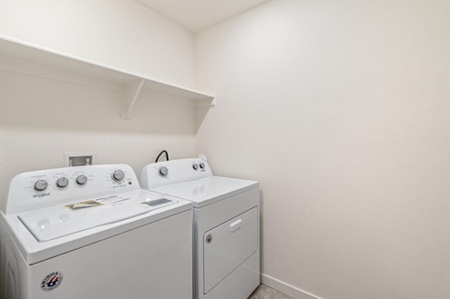 laundry room with a washer, dryer and shelves