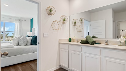 Primary bedroom with attached bathroom featuring double vanity sinks