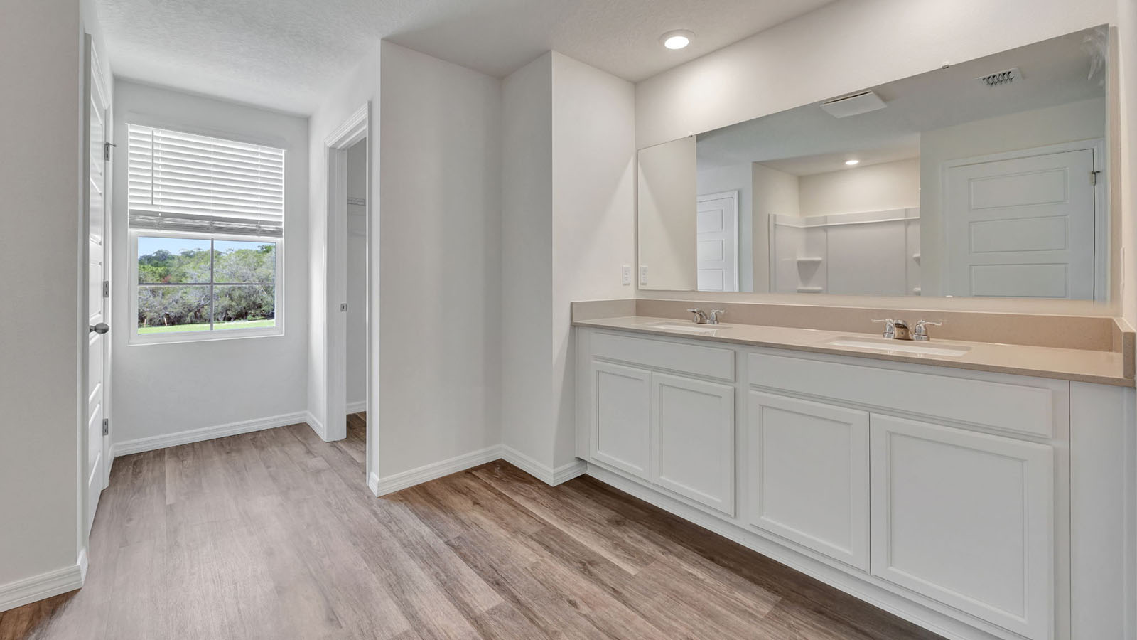 Primary bathroom with dual vanity sink and luxury vinyl plank