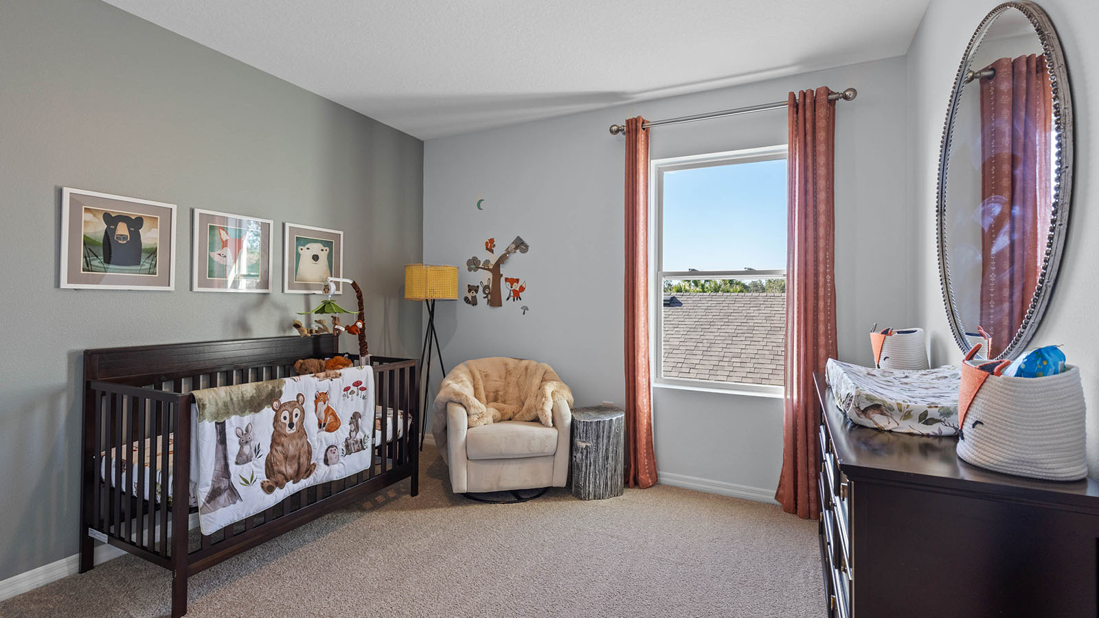 Guest bedroom staged as a nursery with crib, changing table and rocking chair