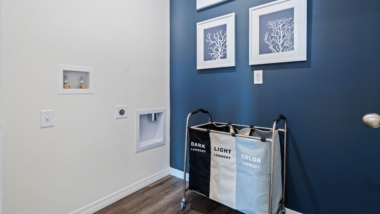 Laundry room with laundry baskets and art