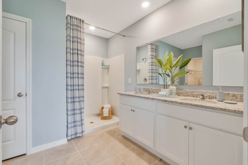 Spacious primary bathroom with dual vanity sink and walk in shower