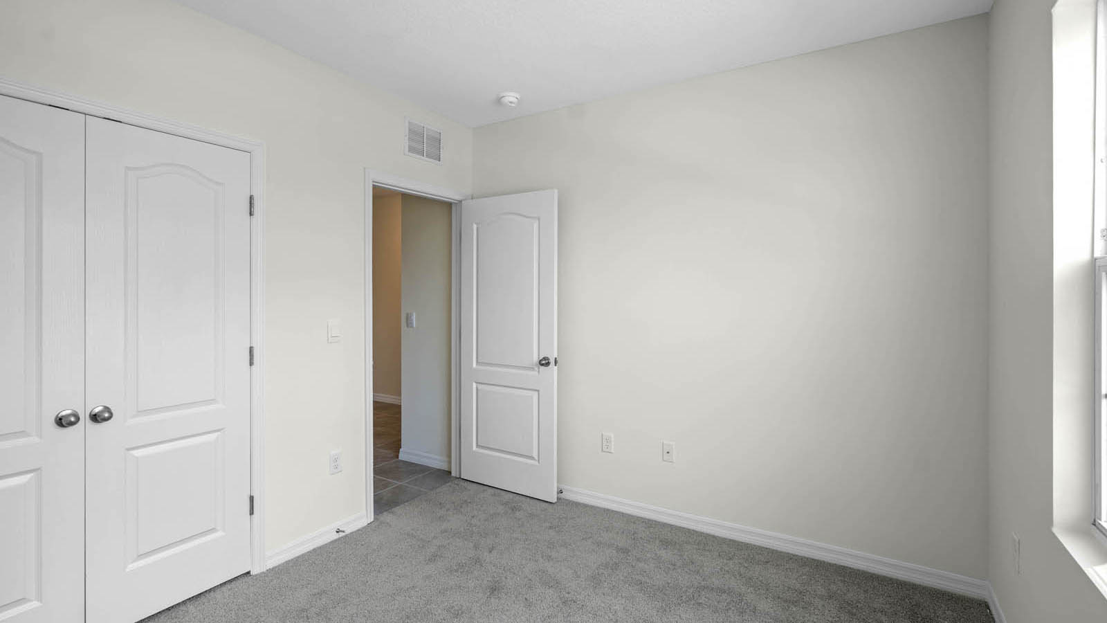 Main floor guest bedroom with carpet
