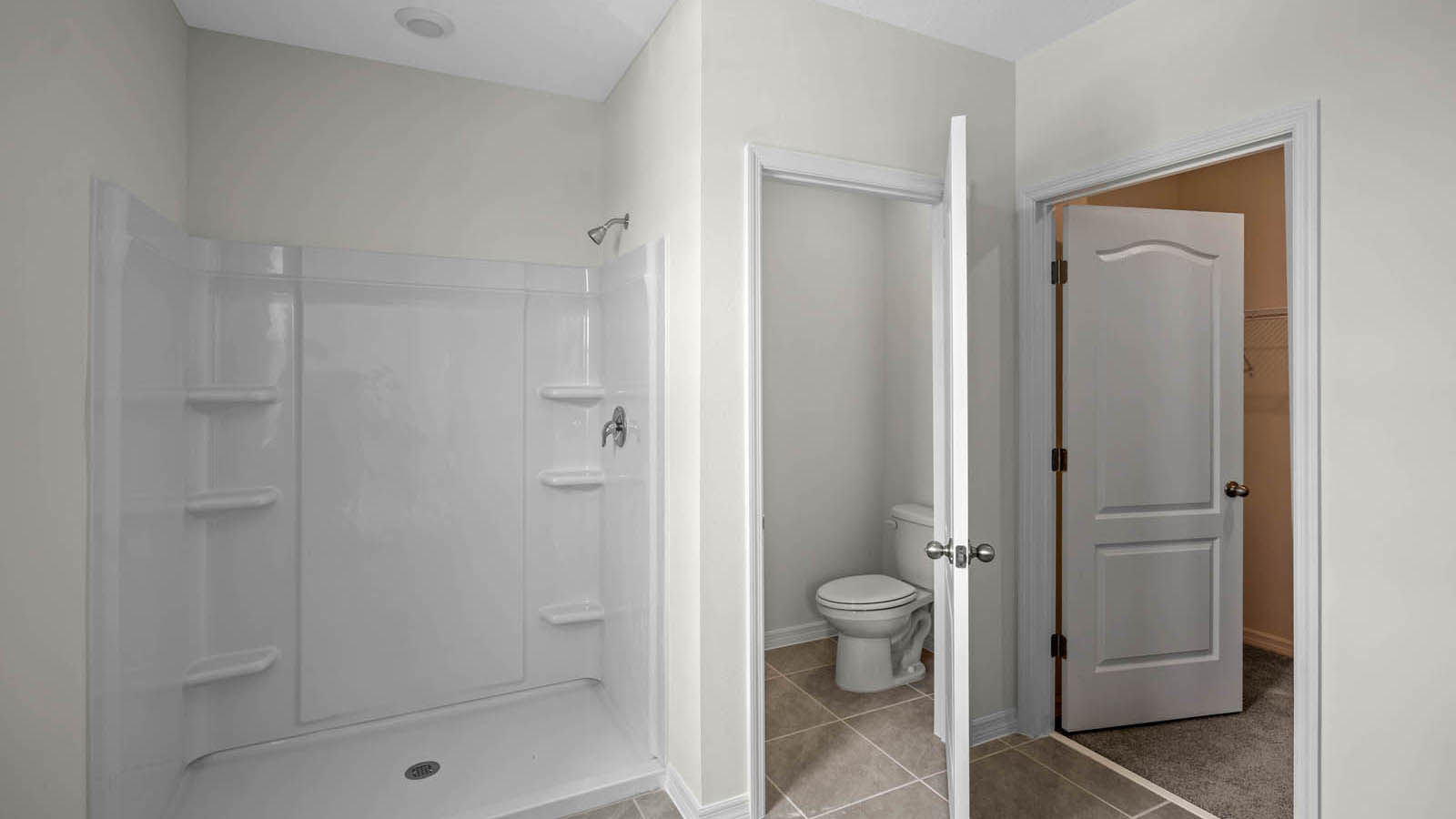 Primary bathroom with walk in closet and walk in shower