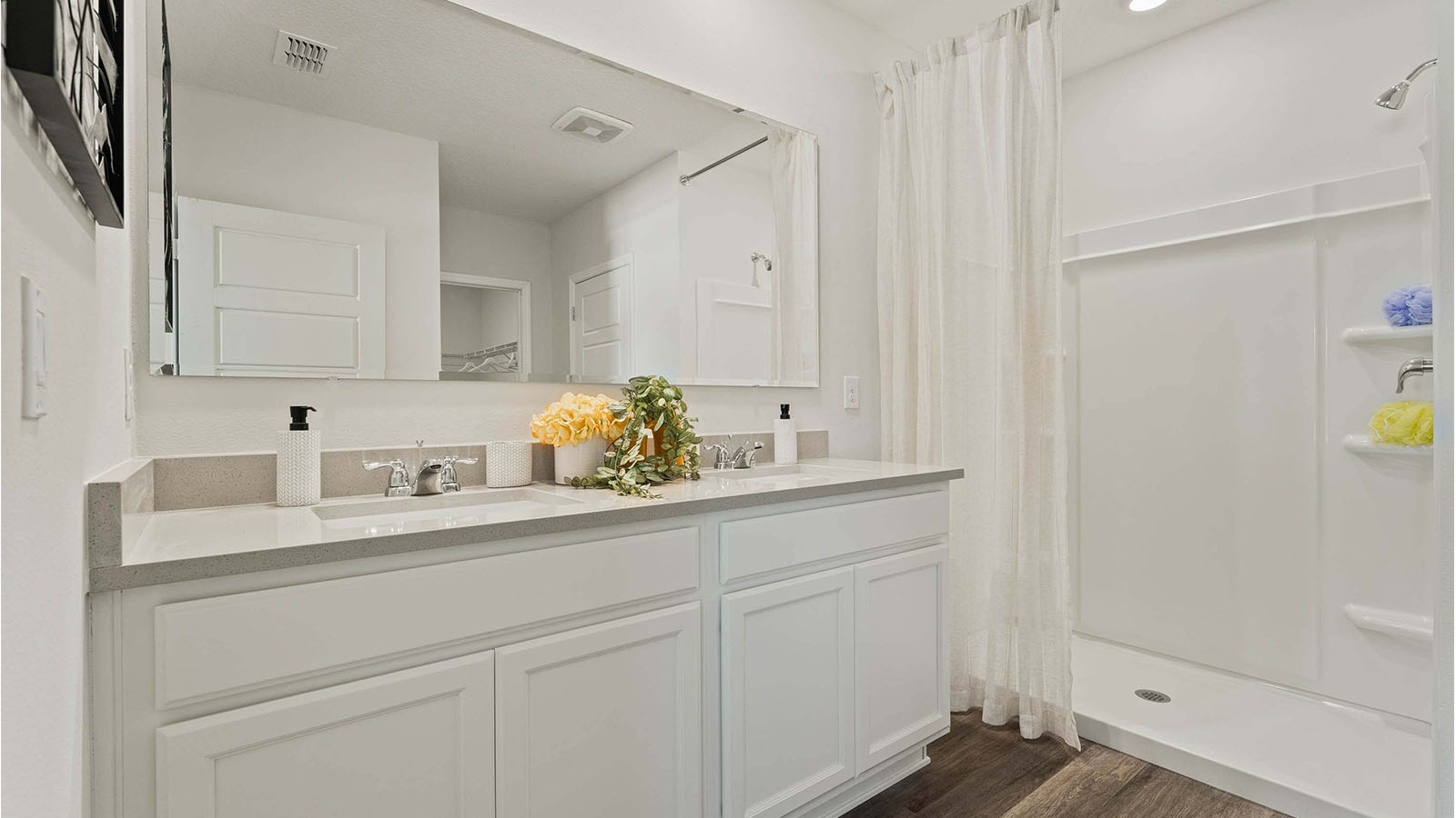 Primary bathroom with luxury vinyl plank and dual vanity sink