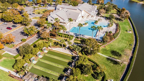 Aerial view of bocce ball, resort-style pool, and clubhouse