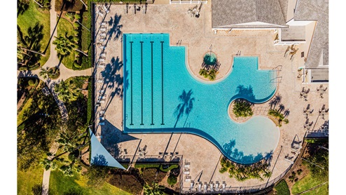 Aerial view of resort-style pool with beach entry and swimming laps