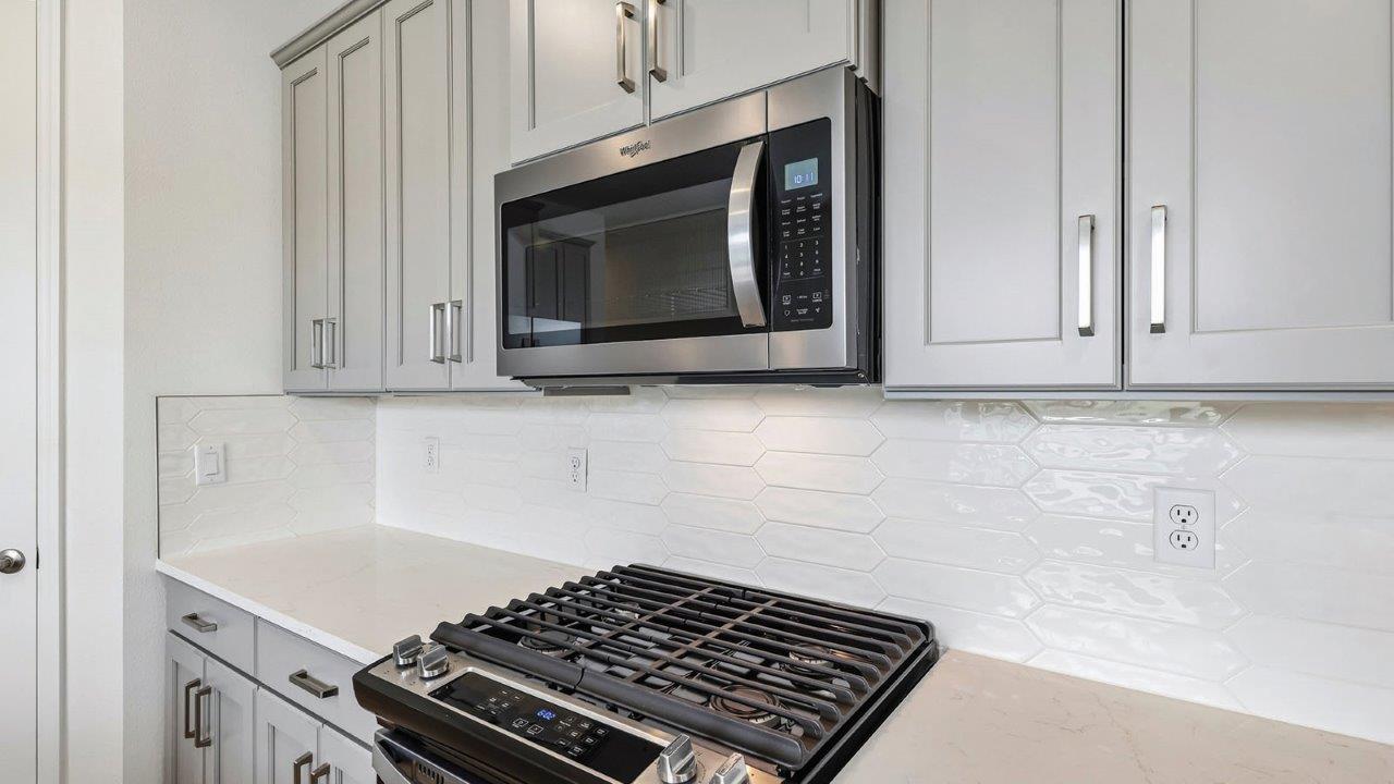 Kitchen with gas stove and stainless steel microwave