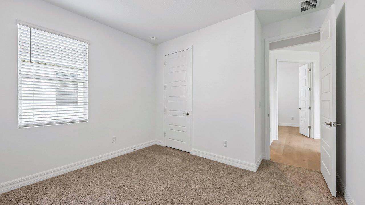 Guest bedroom with carpet and built in closet