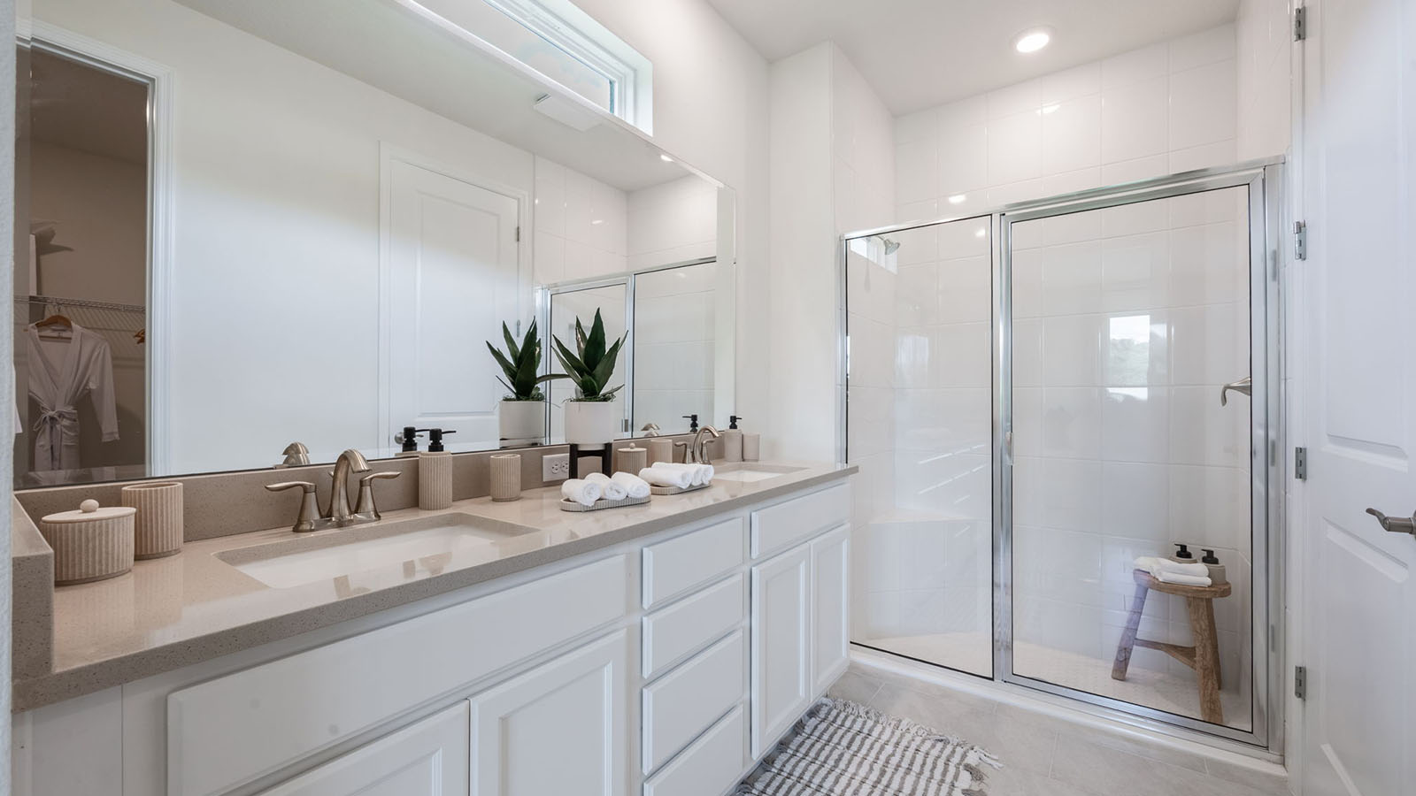 Primary bathroom with double vanity sinks and enclosed walk in shower