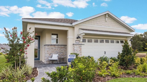 Single story home with two-car garage, stone accents, and front porch
