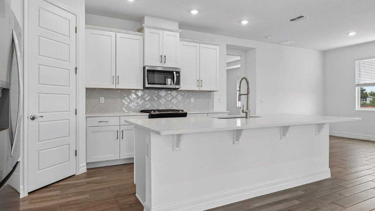 Kitchen with tile backsplash, large island, and eating space