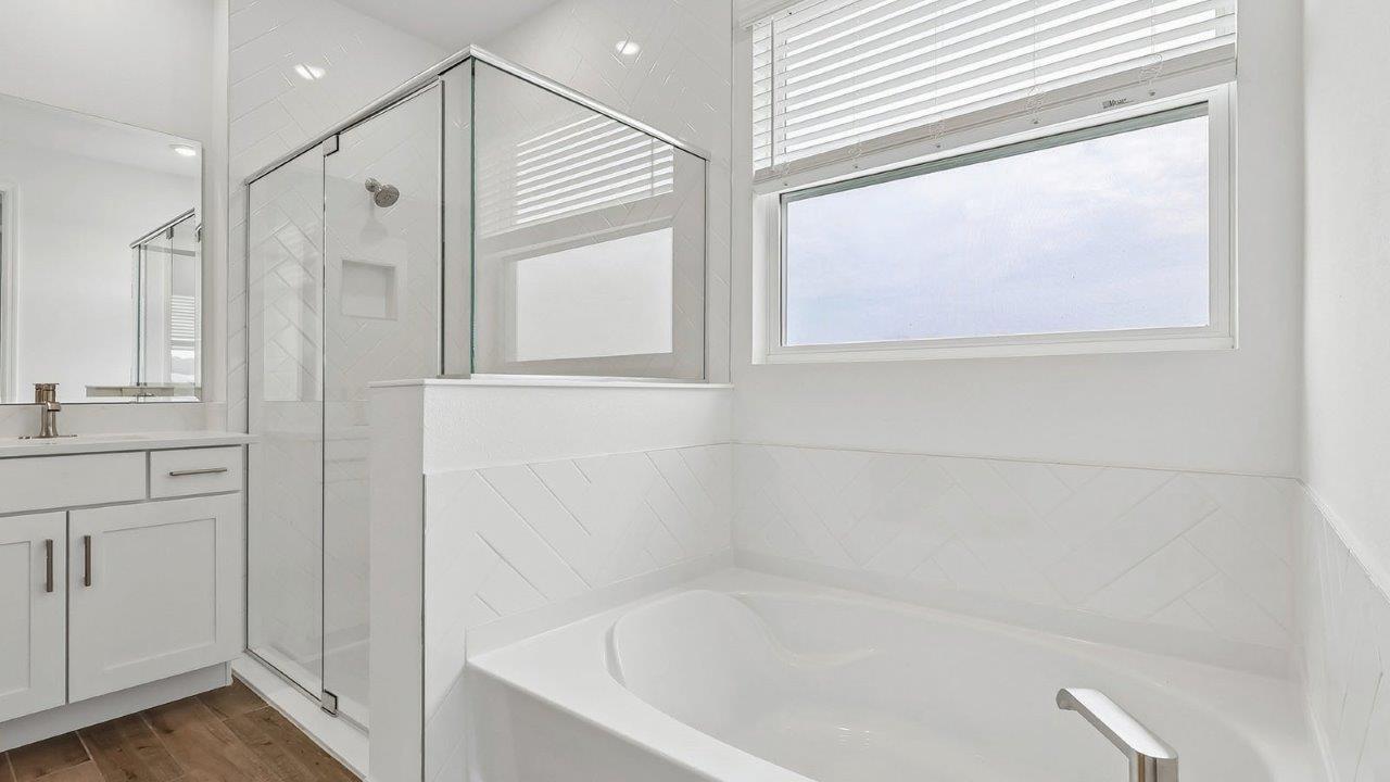 primary bathroom with walk in shower and soaking tub