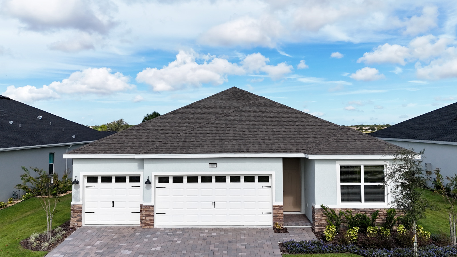 Exterior image of single-story home with 3 car garage and stone accents