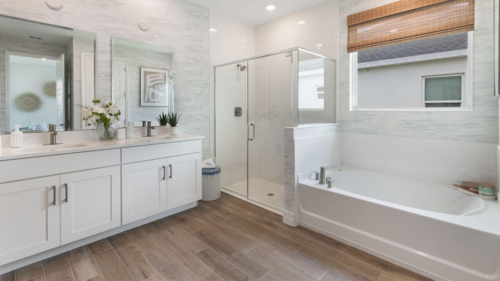Primary bathroom with garden tub, enclosed shower, and dual vanity sinks