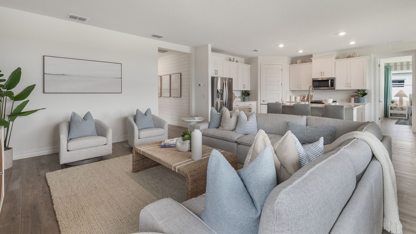 Spacious living room with large sectional and view of kitchen