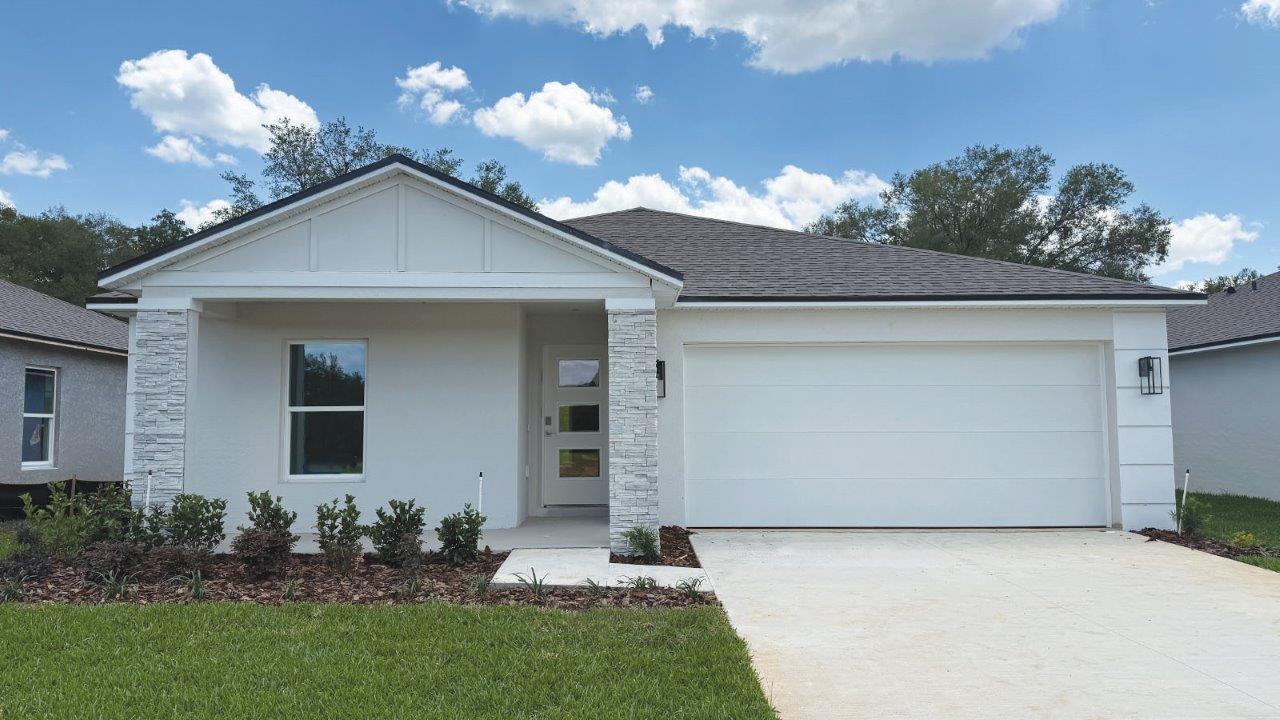Front exterior image of a single-family home with 2-car garage, front porch, and stone-accents