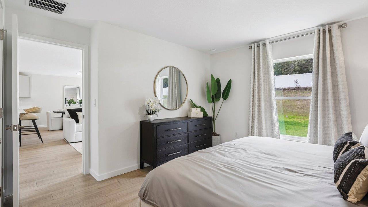 Primary bedroom with king size bed and dresser