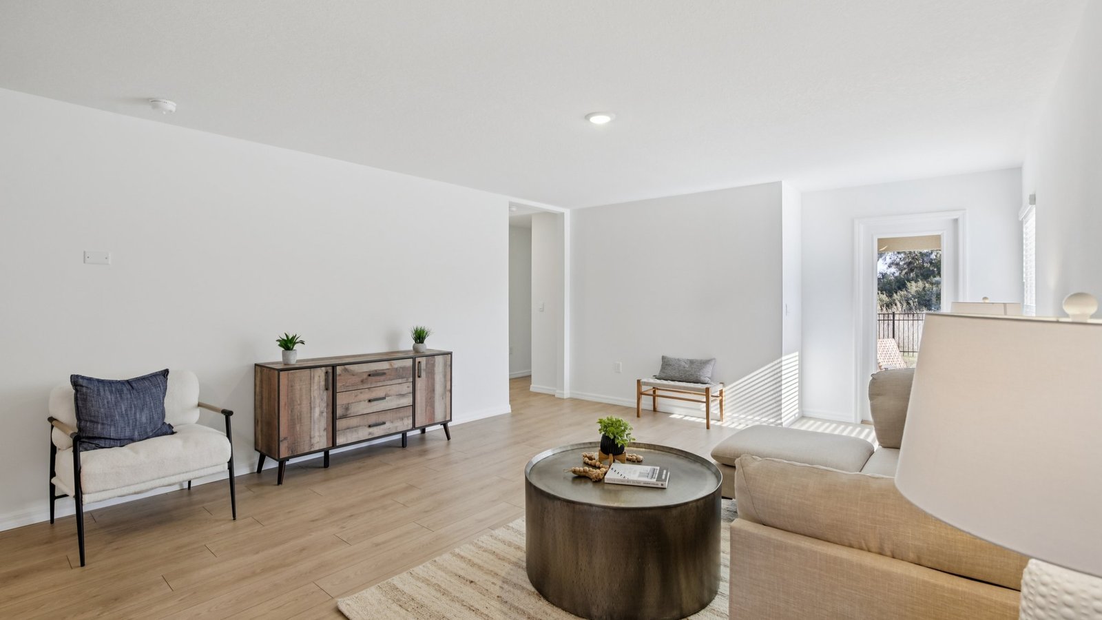 Open concept living area with couch seating and access to the backyard thru slider door.