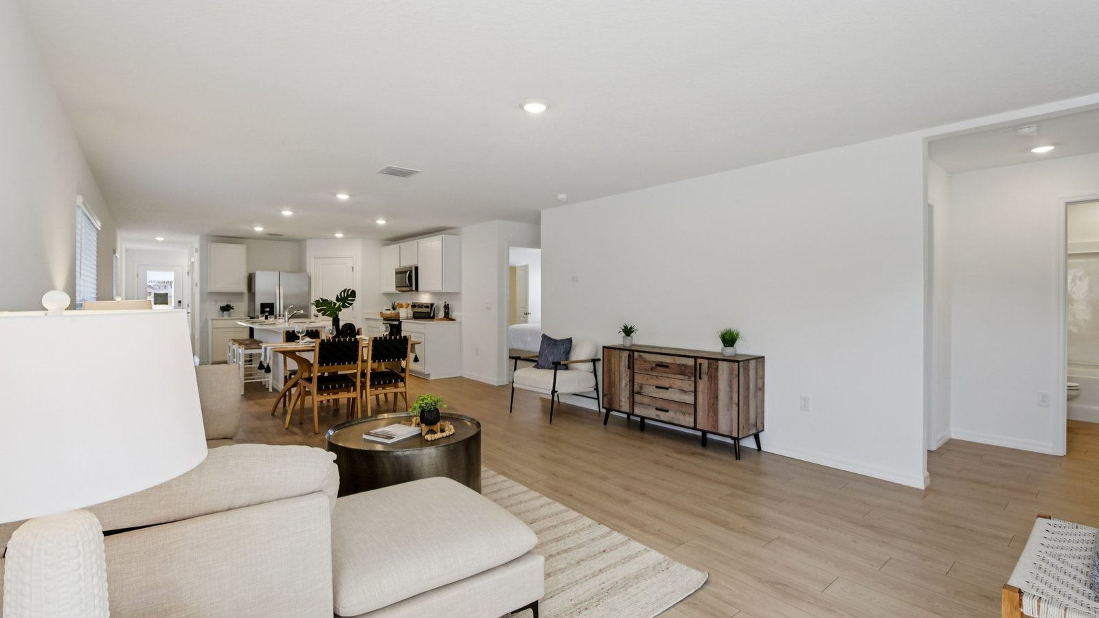 Open concept living area with couch seating and access to the backyard thru slider door.