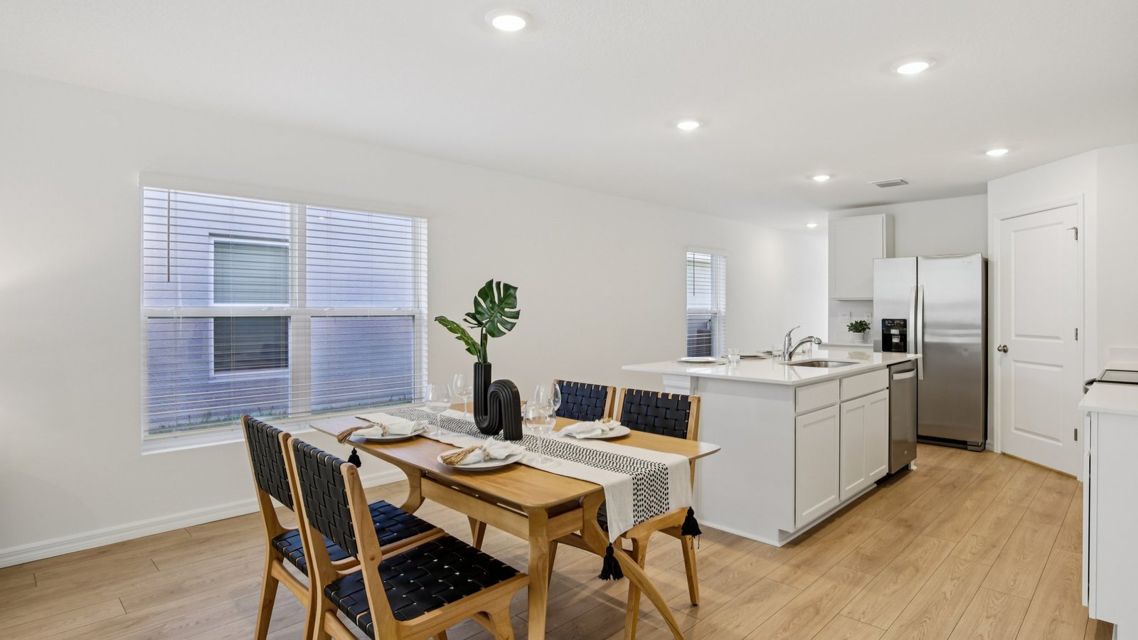 Dining room adjacent to the kitchen with table, chairs and LVP flooring.