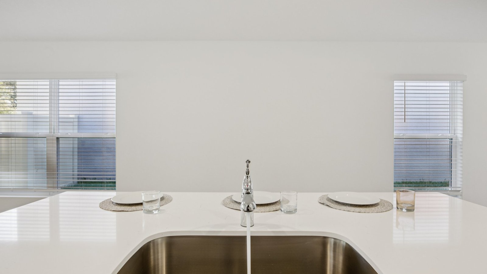 Kitchen with island seating, quartz counters, spacious pantry and stainless-steel appliances.