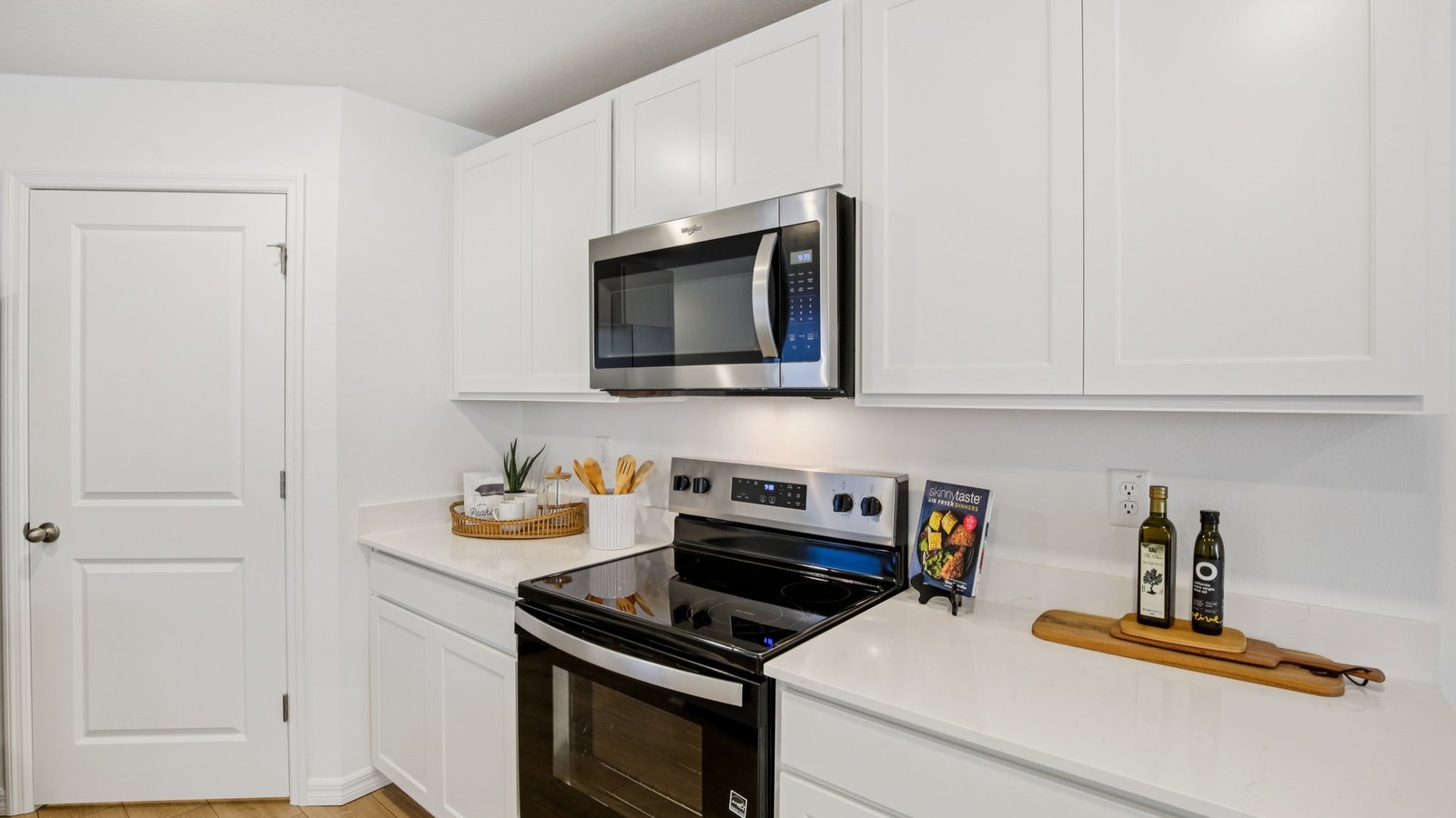 Kitchen with island seating, quartz counters, spacious pantry and stainless-steel appliances.