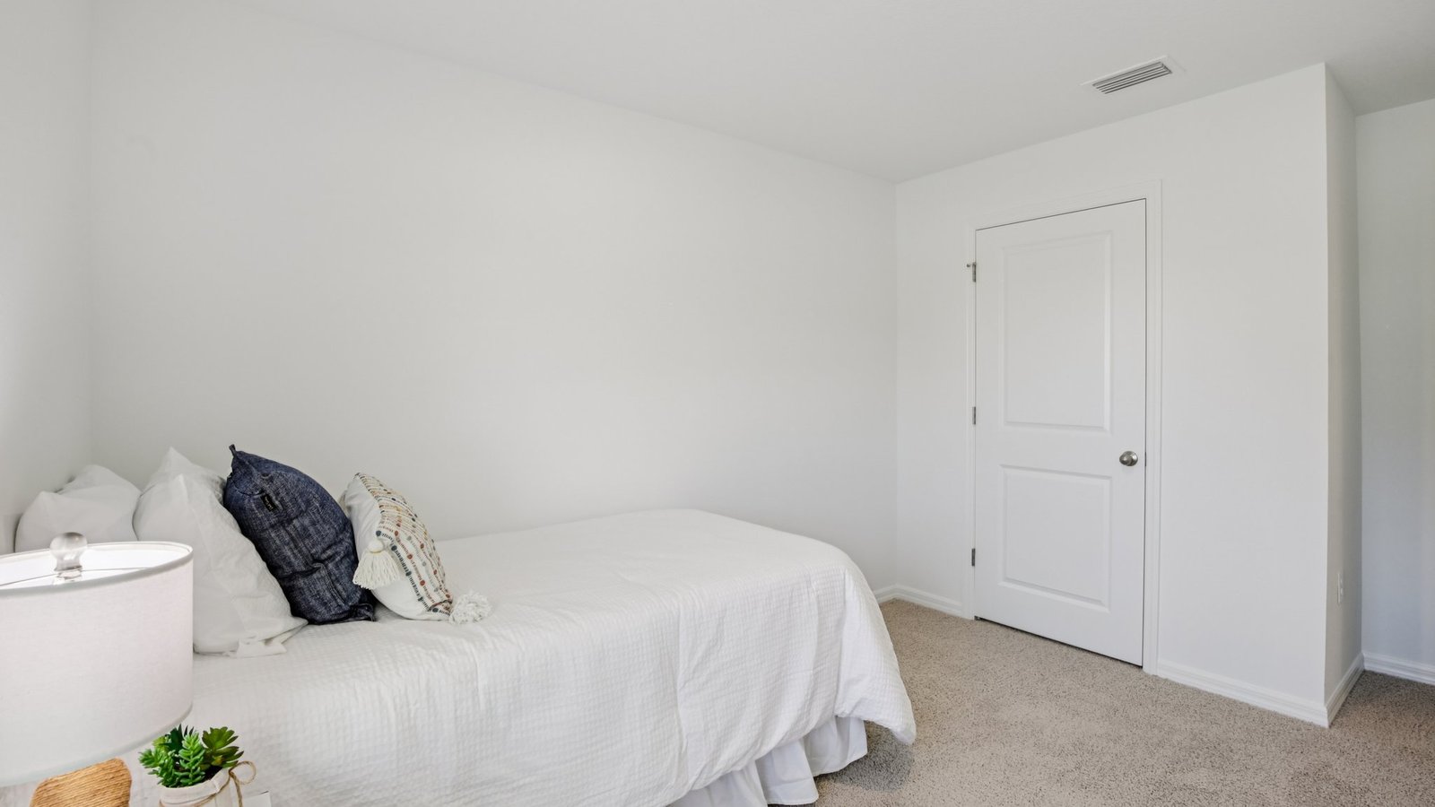 Spare bedroom for guests, with bed, dresser, and ample closet storage.