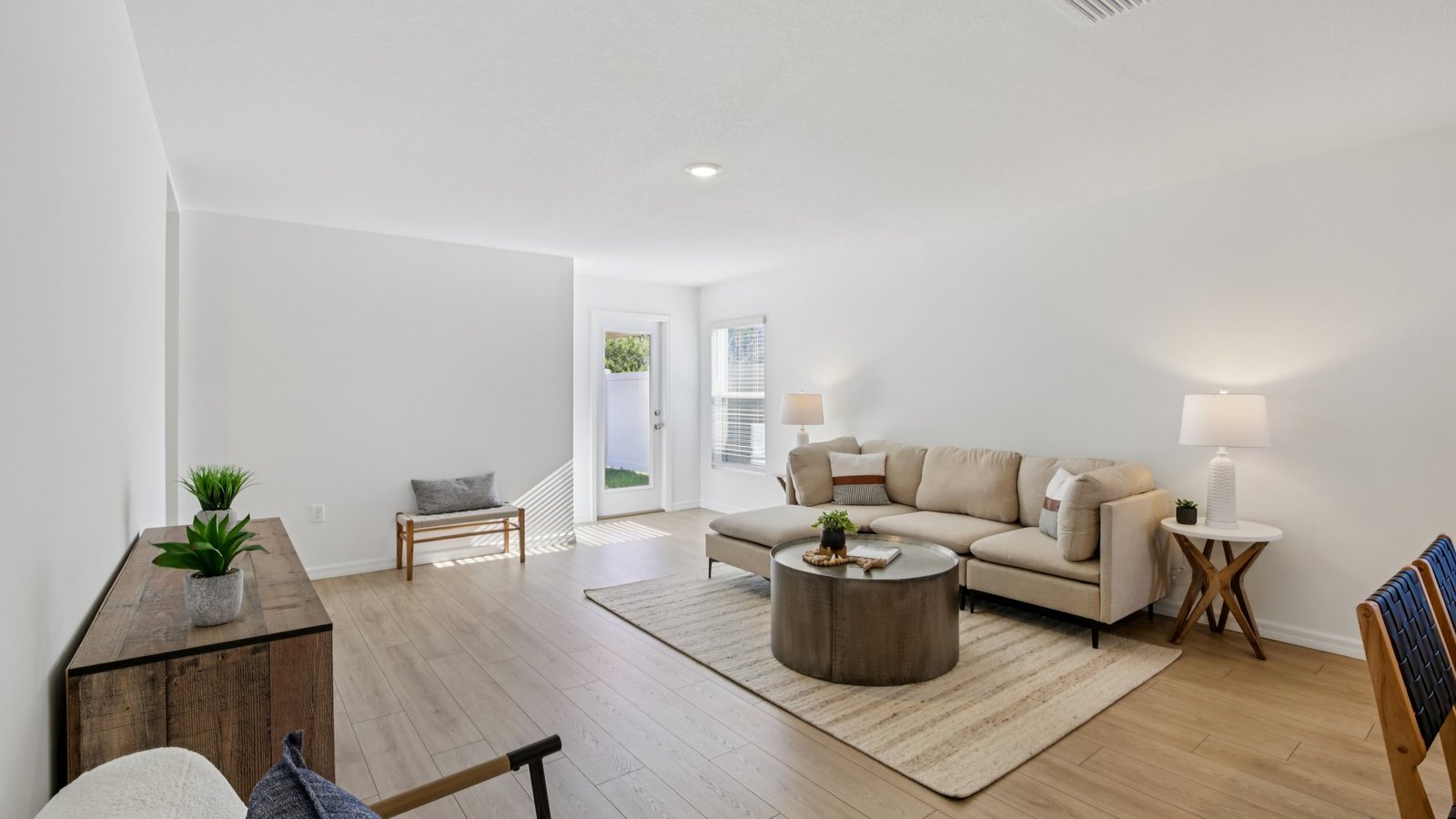 Open concept living area with couch seating and access to the backyard thru slider door.