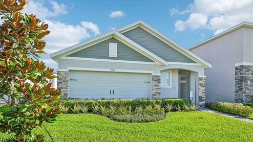 Single story new home with stucco, covered porch and 2 car garage. New construction land O Lakes.