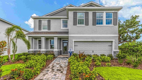 Two-story new home with stucco, covered porch and 2 car garage. New construction land O Lakes.
