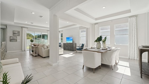 Dining room adjacent to the kitchen with table, chairs and tile flooring. New construction land O Lakes.