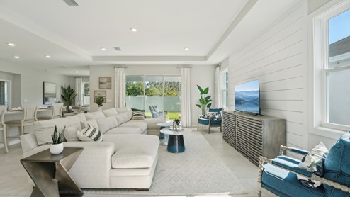 Open concept living area with couch seating and access to the backyard thru slider door. New construction land O Lakes.