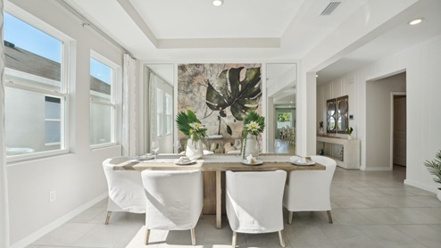 Dining room adjacent to the kitchen with table, chairs and tile flooring. New construction land O Lakes.